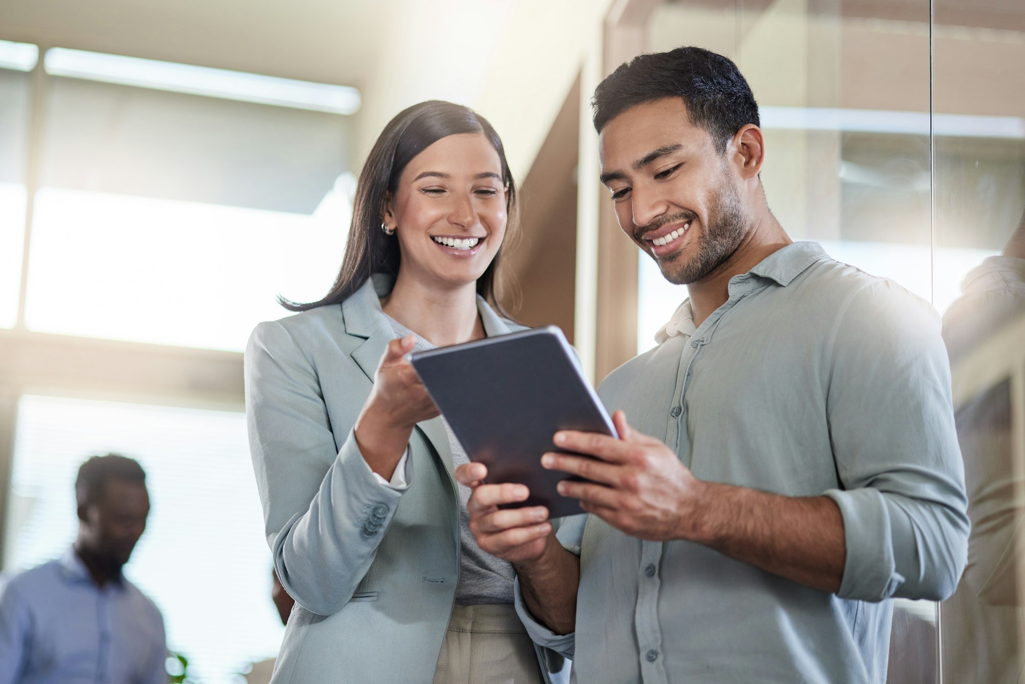 A man and woman in an office looking at automation solutions on at tablet